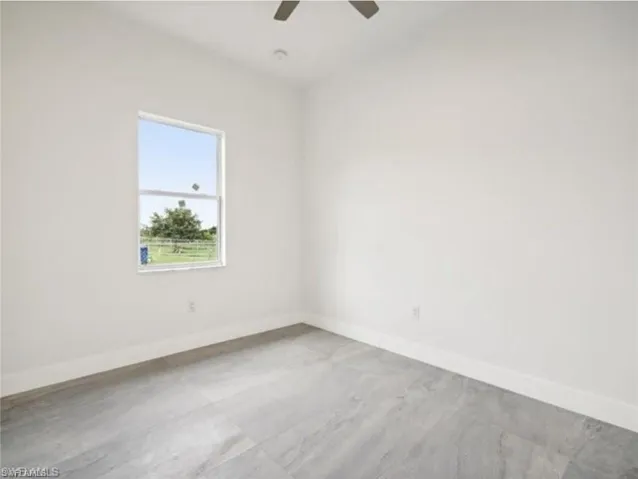 Spare room with baseboards and ceiling fan