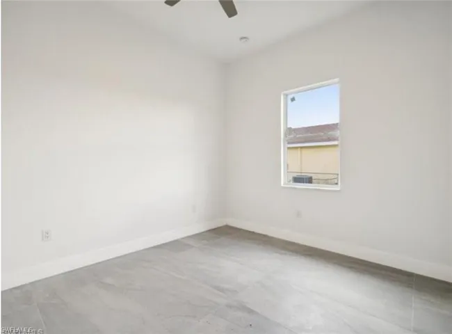 Spare room featuring baseboards and a ceiling fan