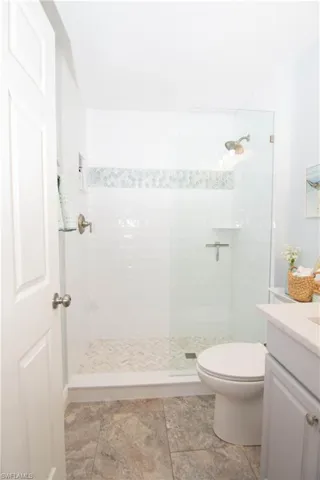 Full bathroom with vanity, toilet, and tiled shower