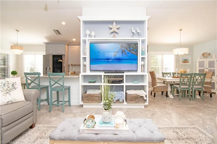 The living room features a beautiful custom built in shelving unit for the television and art display.