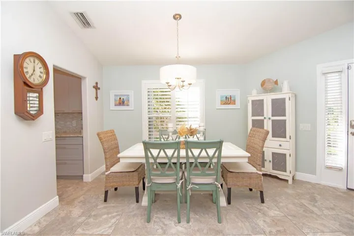 Dining area features a wealth of natural light, a stylish chandelier and a table to accommodate 6-8 guests.