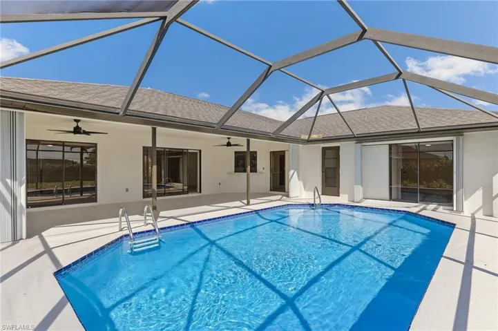 Outdoor pool featuring a lanai, ceiling fan, and a patio
