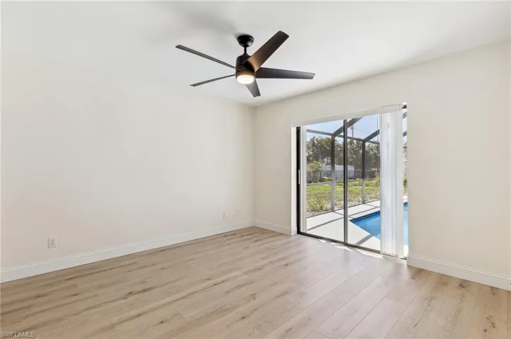 Unfurnished room with light wood finished floors, ceiling fan, baseboards, and a sunroom