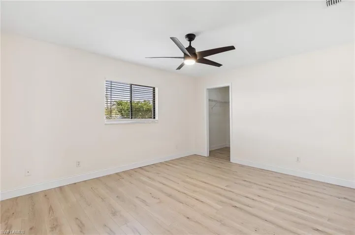 Empty room featuring ceiling fan, light wood finished floors, and baseboards