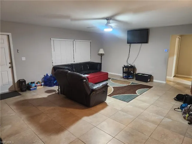 Living area with light tile patterned floors and ceiling fan