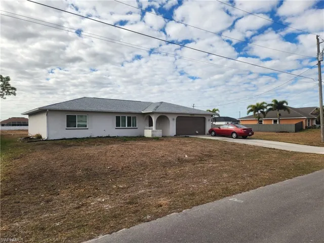 Ranch-style house featuring driveway, stucco siding, and an attached garage