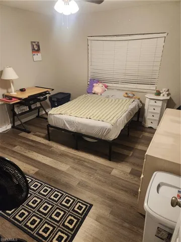Bedroom featuring dark wood-type flooring and ceiling fan