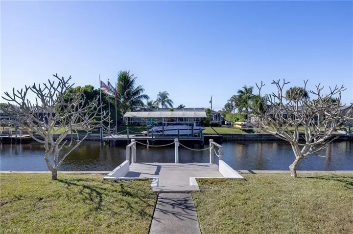 Dock area featuring a yard, boat lift, and a water view