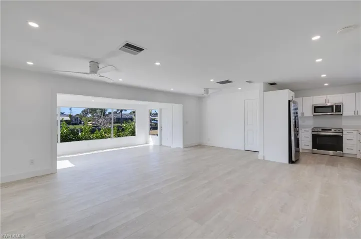 Unfurnished living room featuring light wood-type flooring, a ceiling fan, and recessed lighting