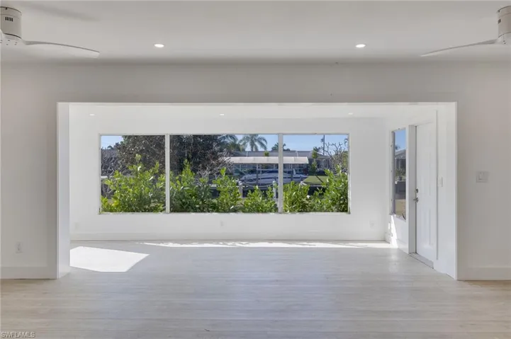 Unfurnished room featuring a ceiling fan, healthy amount of natural light, light wood-style floors, and recessed lighting