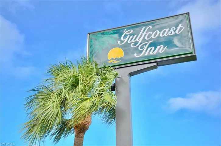Prominent commercial signage featuring "Gulfcoast Inn" against a clear blue sky