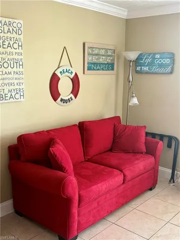Wall-to-wall ceramic tile flooring featuring a warm tone, crown molding, and neutral wall paint