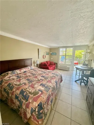 Open-concept living space featuring ceramic tile flooring and crown molding
