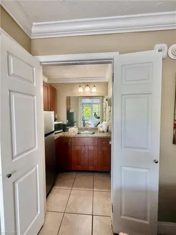 Kitchen featuring wood cabinetry, a stainless steel refrigerator, and a coordinating countertop