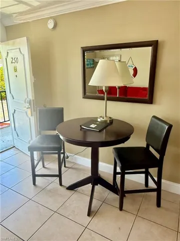 Compact dining area featuring a round dark wood-finish table and two matching high-back chairs