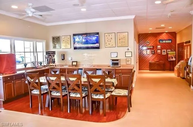Spacious dining area featuring wood-finish flooring, ample natural light from multiple windows, recessed lighting, and a ceiling fan