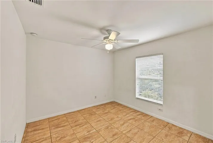 Tile flooring, neutral wall tones, ceiling fan with integrated lighting, and window with blinds