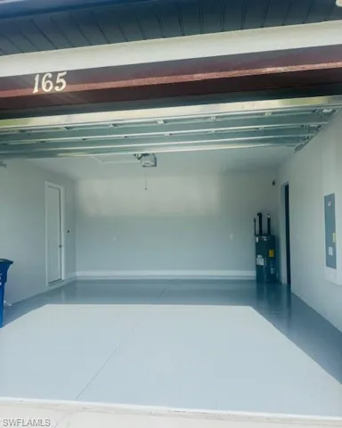 Garage featuring water heater and electric panel