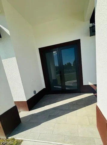 View of exterior entry with french doors and stucco siding