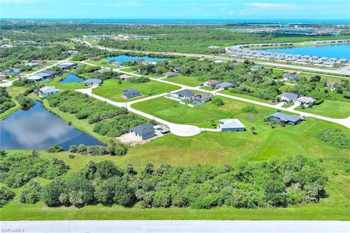Aerial perspective of suburban area featuring a nearby body of water