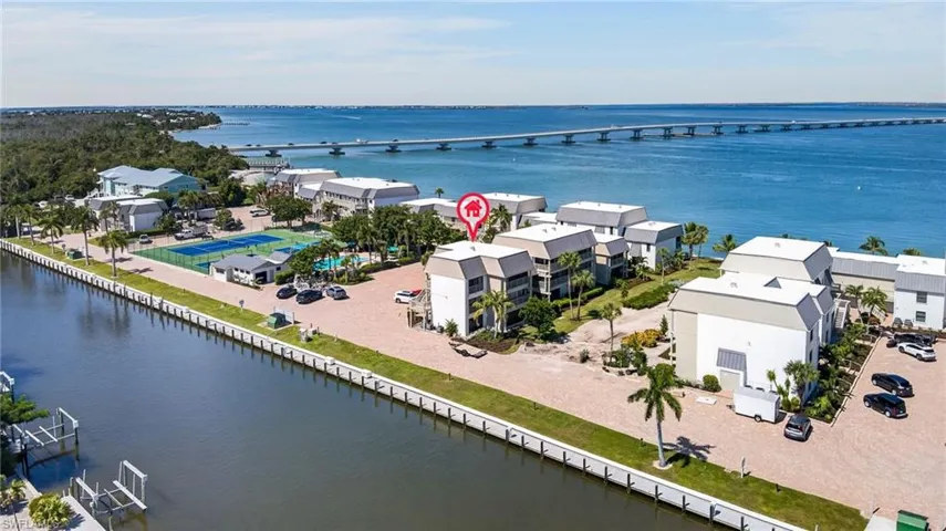 Waterfront property featuring multiple buildings, direct water access, tennis courts, and a swimming pool