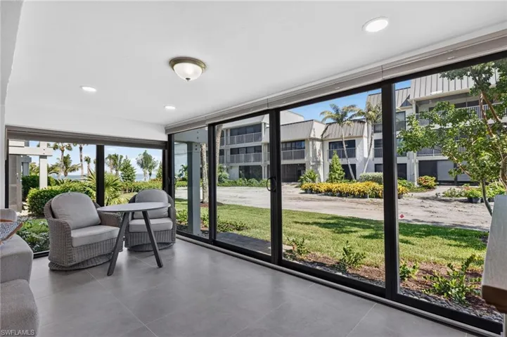 Expansive sliding glass doors, recessed lighting, tile flooring, and a flush mount ceiling fixture