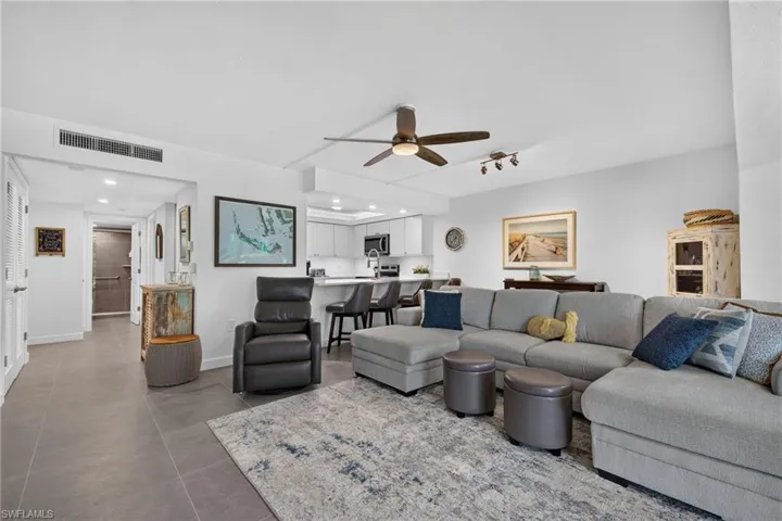 Open-concept living area with gray tile flooring, a ceiling fan, and recessed lighting