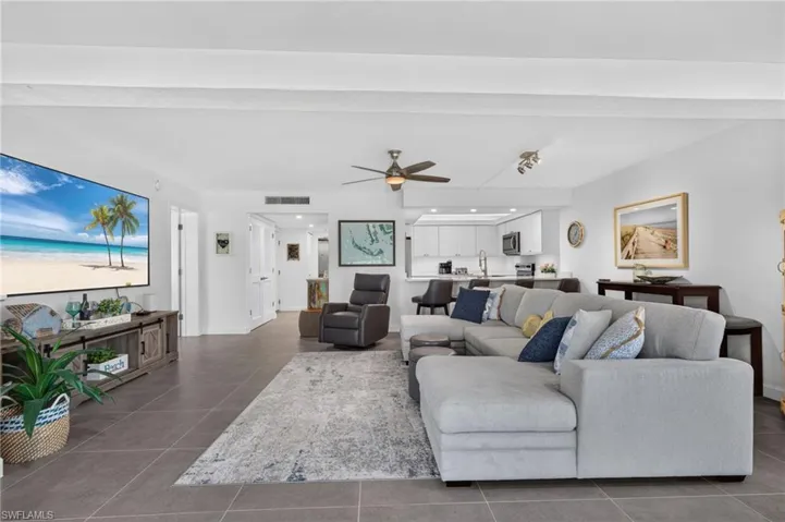 Open-concept living area with large format tile flooring, a ceiling fan, and recessed lighting