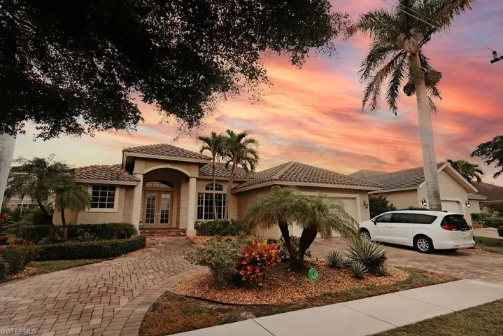 Mediterranean / spanish-style home featuring stucco siding, decorative driveway, a tile roof, an attached garage, and french doors