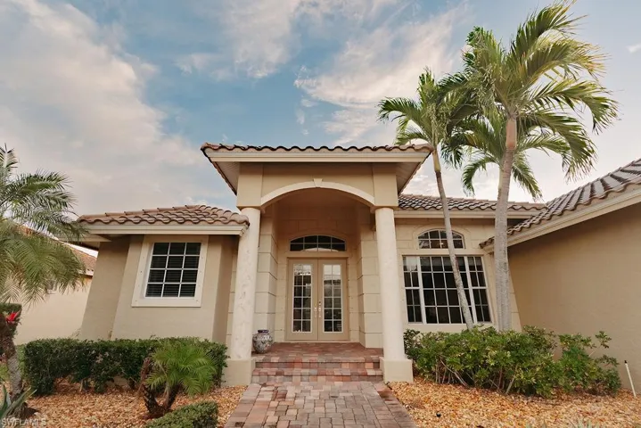 Doorway to property with french doors, stucco siding, and a tiled roof