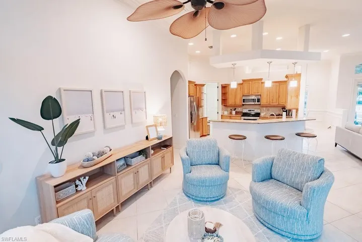 Sunroom/second living room area featuring arched walkways, a high ceiling, ceiling fan, recessed lighting, and light tile patterned flooring