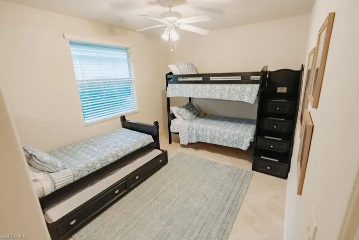 Second guest bedroom with ceiling fan and 3 twin beds