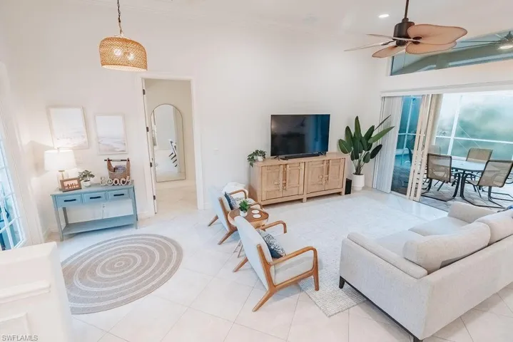 Front living room area featuring crown molding, light tile patterned floors, and a ceiling fan