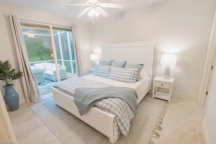 Guest bedroom with slider to paver back patio lounge area and pool