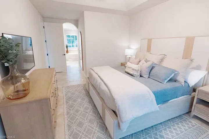 Spacious master bedroom with arched walkways and connected bathroom