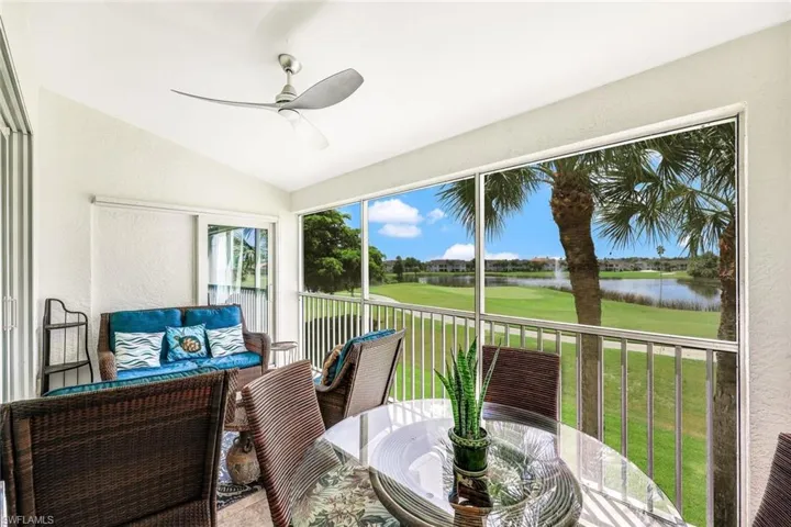 Sunroom / solarium featuring a water view, ceiling fan, and vaulted ceiling