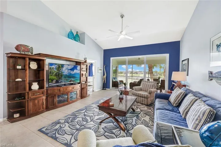 Tiled living room with high vaulted ceiling and ceiling fan