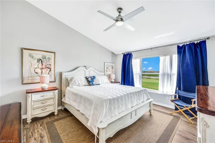Bedroom with lofted ceiling, ceiling fan, and dark hardwood / wood-style flooring