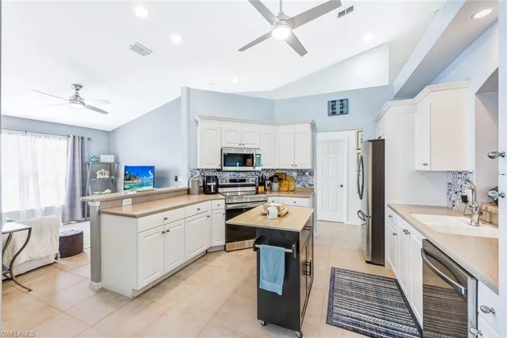 Kitchen with ceiling fan, stainless steel appliances, and white cabinets