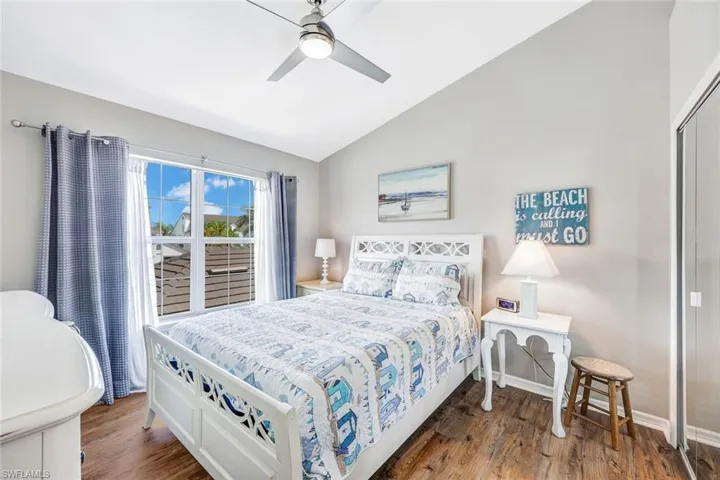 Bedroom featuring dark wood-type flooring, ceiling fan, a closet, and vaulted ceiling