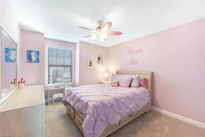 Bedroom with ceiling fan and light colored carpet