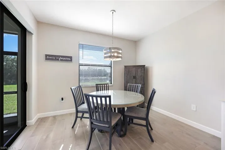 Dining space with a notable chandelier and light hardwood / wood-style floors