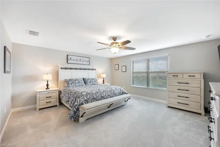 Bedroom with ceiling fan and light colored carpet