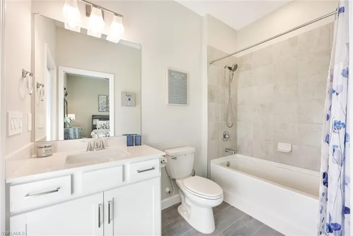 Full bathroom with shower / tub combo, hardwood / wood-style floors, vanity, and toilet
