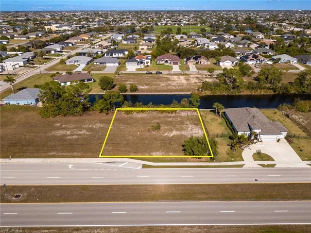 Aerial view of residential area featuring property parcel outlined and a large body of water