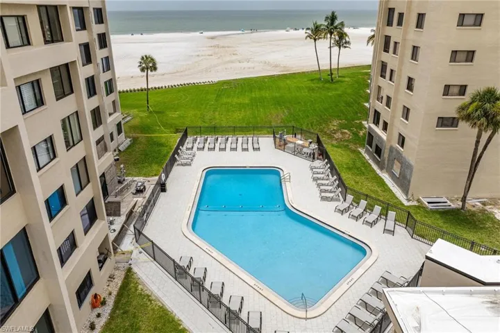 View of pool with a water view, a patio area, and a lawn