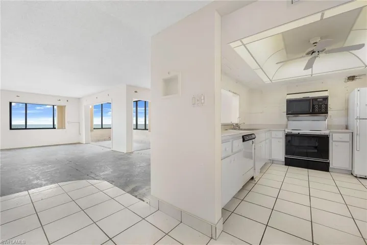 Kitchen with white cabinetry, white appliances, sink, and ceiling fan