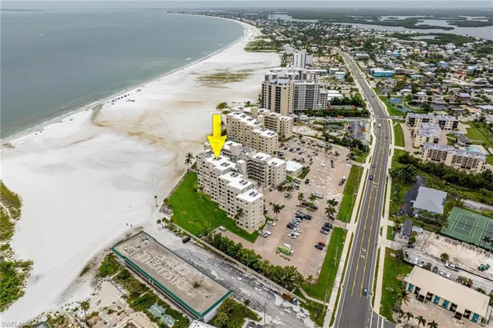 Birds eye view of property with a water view and a view of the beach