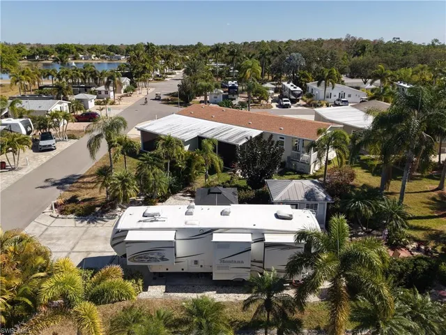 Aerial view of residential area featuring a tree filled landscape and a large body of water