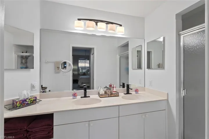 Primary Bathroom located just beyond the walk-in closet, linen closet and bathroom featuring double sink vanity and spacious shower